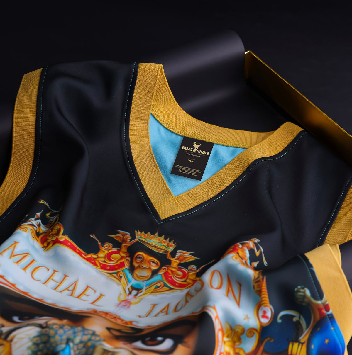 Close-up of the GOAT SKINS Michael Jackson limited edition collectible jersey showing the gold-trimmed collar, inner label and detailed artwork