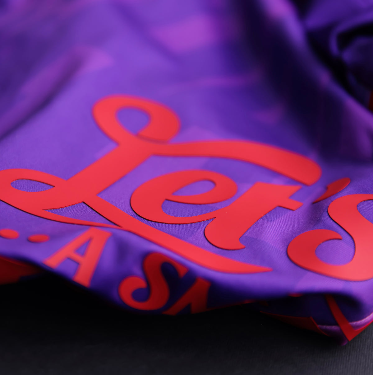 Close-up of the GOAT SKINS Joker limited edition collectible jersey showing the red Let’s Put a Smile design on purple fabric