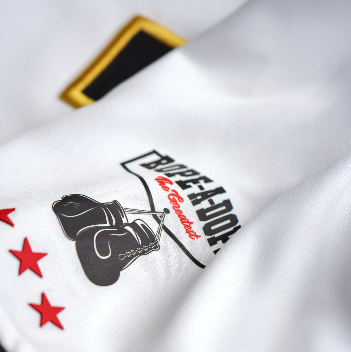 Close-up of the GOAT SKINS Muhammad Ali limited edition collectible jersey showing the Rope-a-Dope boxing gloves and red star detail